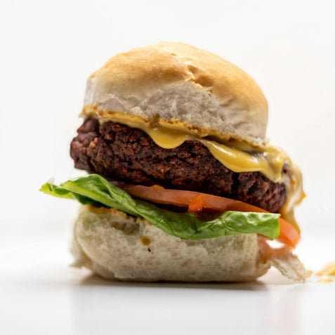 A plant burger, with lettuce, tomato and dairy free cheese sauce made using Special Ingredients Nutritional Yeast Flakes and Tapioca Flour.