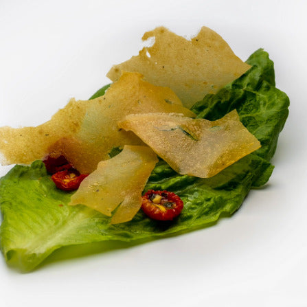 Delicate crispy parmesan shards made with Special Ingredients Nutritional Yeast, Malic Acid and Ultratex on a bed of lettuce and tomato.