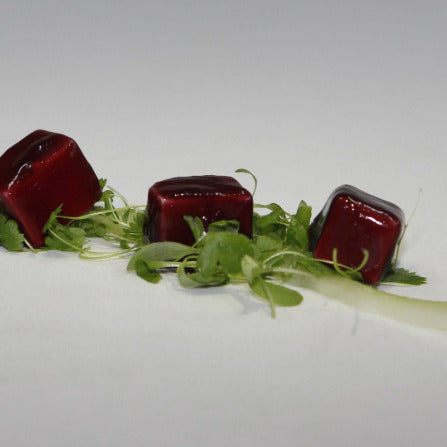 Gats cheese with a port coating lay on a bed of salad garnish.